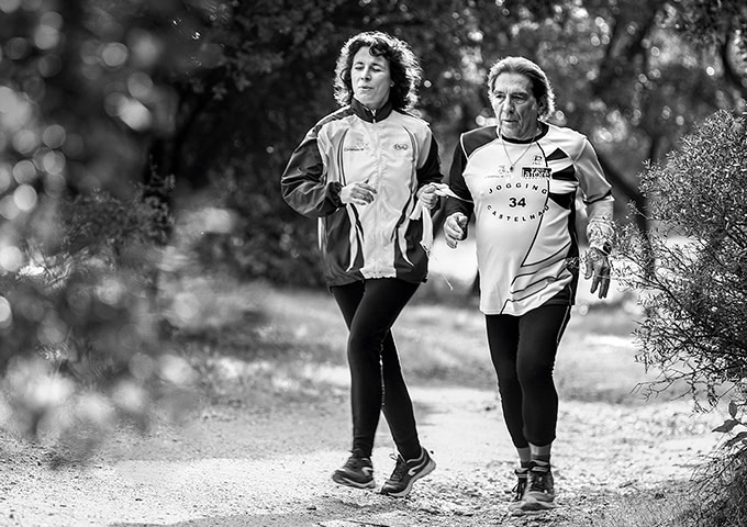 Teresa avec un accompagnant court sur un chemin boisé