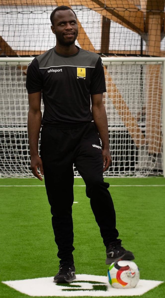 Photo d'Yvan Wouandji en tenue de cécifoot, pied sur le ballon.