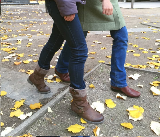 Photo d'un guide et de la personne guidée qui franchissent en simultanée un obstacle. Les deux jambes droites sont avancées en même temps.