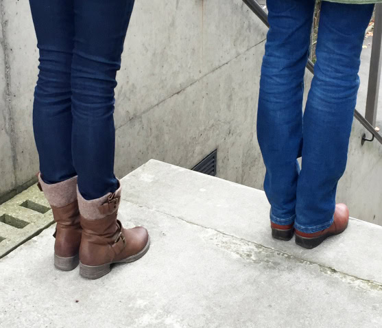 Photo de deux personnes devant un escalier descendant. Le guide est à un pas devant et s'arrête devant la première marche.